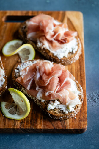 Crostoni di pane nero, ricotta agrumata e Prosciutto di San Daniele